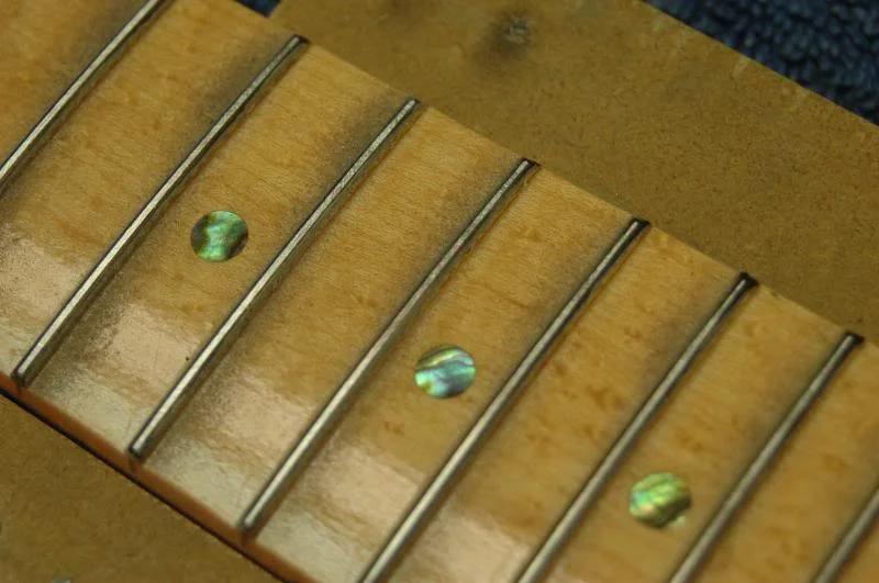 This is what you are looking for. If your neck has the last several frets falling away, that is lower than the rest of the fingerboard, take your fret leveling tool, press down on and over those last few frets from about the 17th on, and level those. This will create a natural incline up to the 16th and lower.