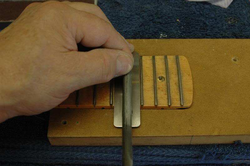  If you’re good, or crazy, I’m not sure.. you can do it like in the previous photo, risking scratching the fingerboard, or you can use a protector, as seen here. 