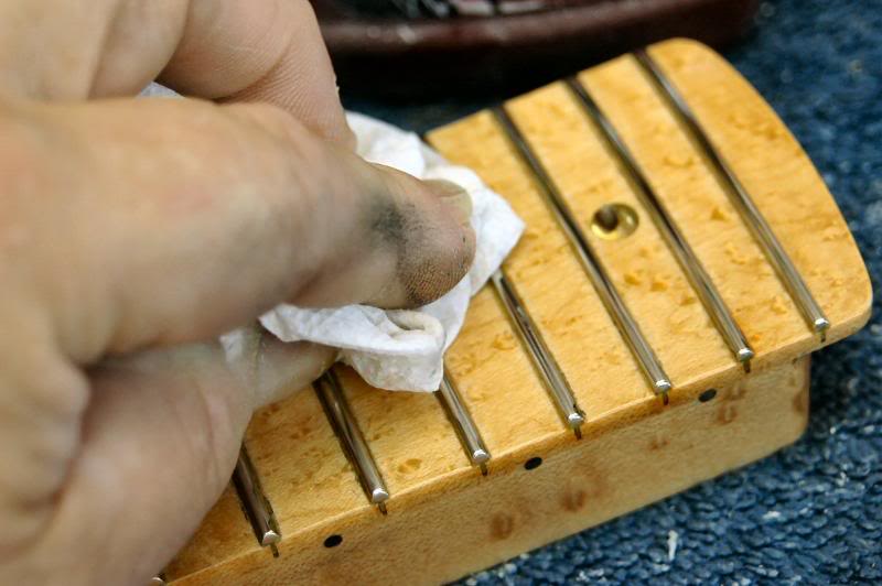 I do the same on the heel, then re mask and do the edge of the heel. Once that’s done I begin polishing the frets, I use several methods, depending on the neck, here I’m going over each with a cleaner car wax. It’s perfect because it will polish the