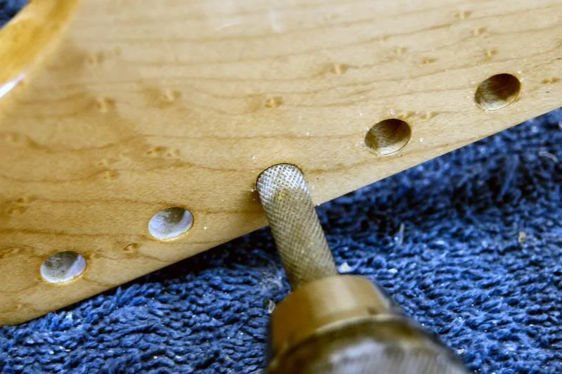First I ream the holes to clear out the lacquer buildup, I use a rotary file so there’s no chance of it grabbing and splitting the head.