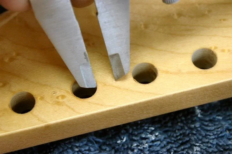 I mark each location to insure they are straight relative to each other. I then take a caliper, dividers, or any precision instrument, and mark the distance from the hole edge to the location of the pin hole.