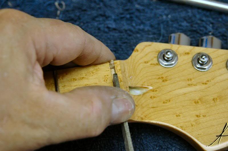  The nut slot needs to be cleared of any accumulated lacquer. I made a tool just to do this by grinding a sharp edge on the end of a file, it scrapes the lacquer from the floor and the sides quite precisely. 