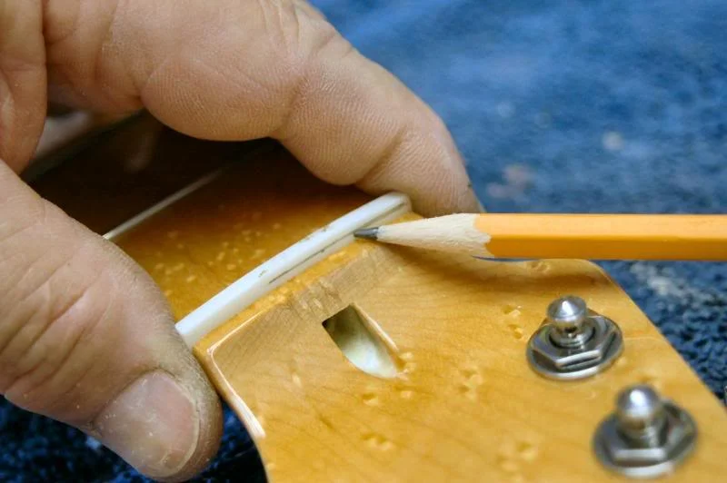 Once it’s seated firmly in the slot, I take a pencil and mark a rough line indicating the top of the nut.