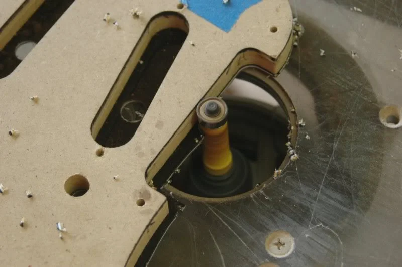 Then over to the router table to circumnavigate the periphery of the pick guard with a straight edge bit.
