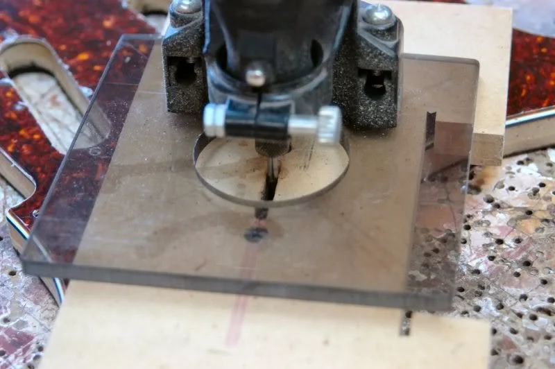I mount the slot template in the existing switch screw holes, and lower the Dremel into the slot. The bit is a 1/16 D rasp.