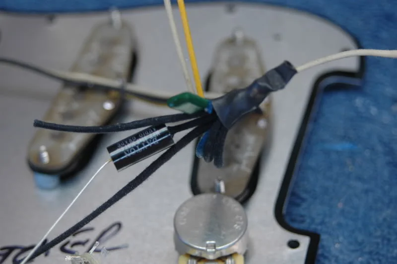 I use an isolated ground through an audio grade capacitor. This dramatically reduces the hum and preserves the classic Strat sound.