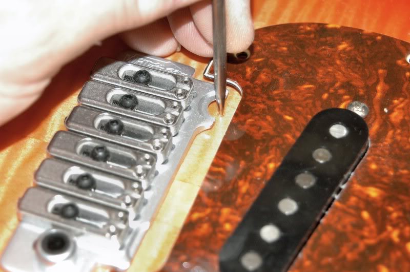  Now I insert the neck, place the pickguard in position, then place the tremolo in the correct position. Measuring from the 12 fret, locate the first bridge 12 ¾", and that’ll be the location of the tremolo. Since the neck and pickguard are in place,