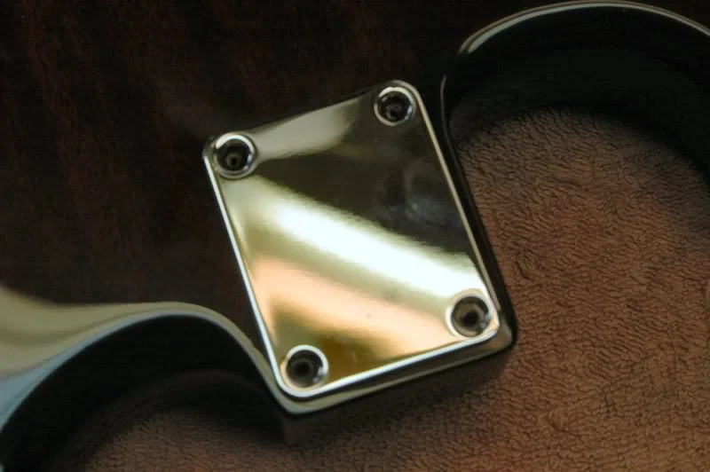 Now I place the neck plate in position, noting the screw holes, getting it as precise as I can.