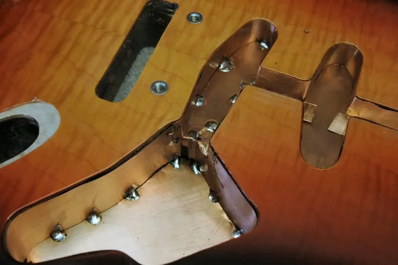 Working around the edges, I solder at about 1 inch intervals. Be careful in the deep section, the back of the guitar and all the beautiful lacquer is only 1/8th inch away. Heat it too much and a blister raises it’s ugly head, and it’s back to refinishing.
