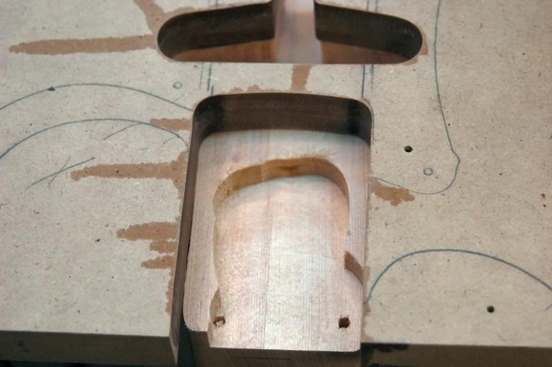  We now have the pickup’s routs to the correct depth.&nbsp;I’ll do the electronics in a later step.&nbsp;Now to the neck pocket.&nbsp;I do this in two cuts too.&nbsp;I set the router to cut approximately ½ (not at all critical) of the depth in the fi
