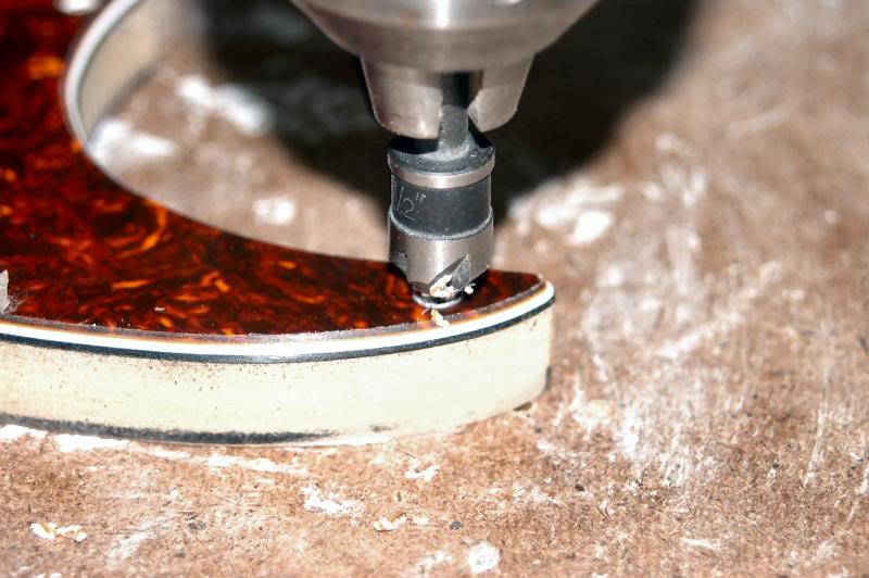  Once the bevel is correct, I move on to countersink the screw holes. I use the layers of the pickguard as a reference, to determine the depth, or you can set the drill press stop and use sheets of paper to work the pickguard up into the countersink 