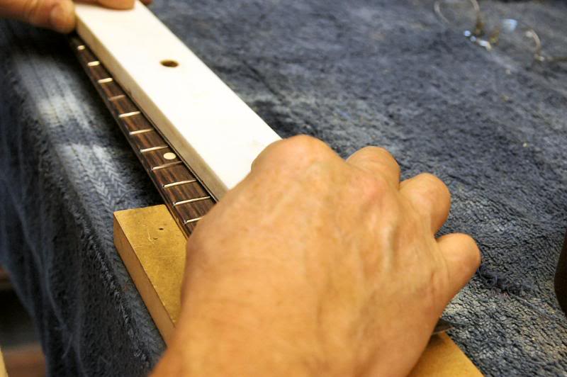  Now I start scrubbing up and down the neck. Allow the weight of the tool to do the work. If you start pressing, even very rigid tools can flex slightly, but by allowing gravity to hold ‘er in place, the cutting is equalized over the entire fret boar