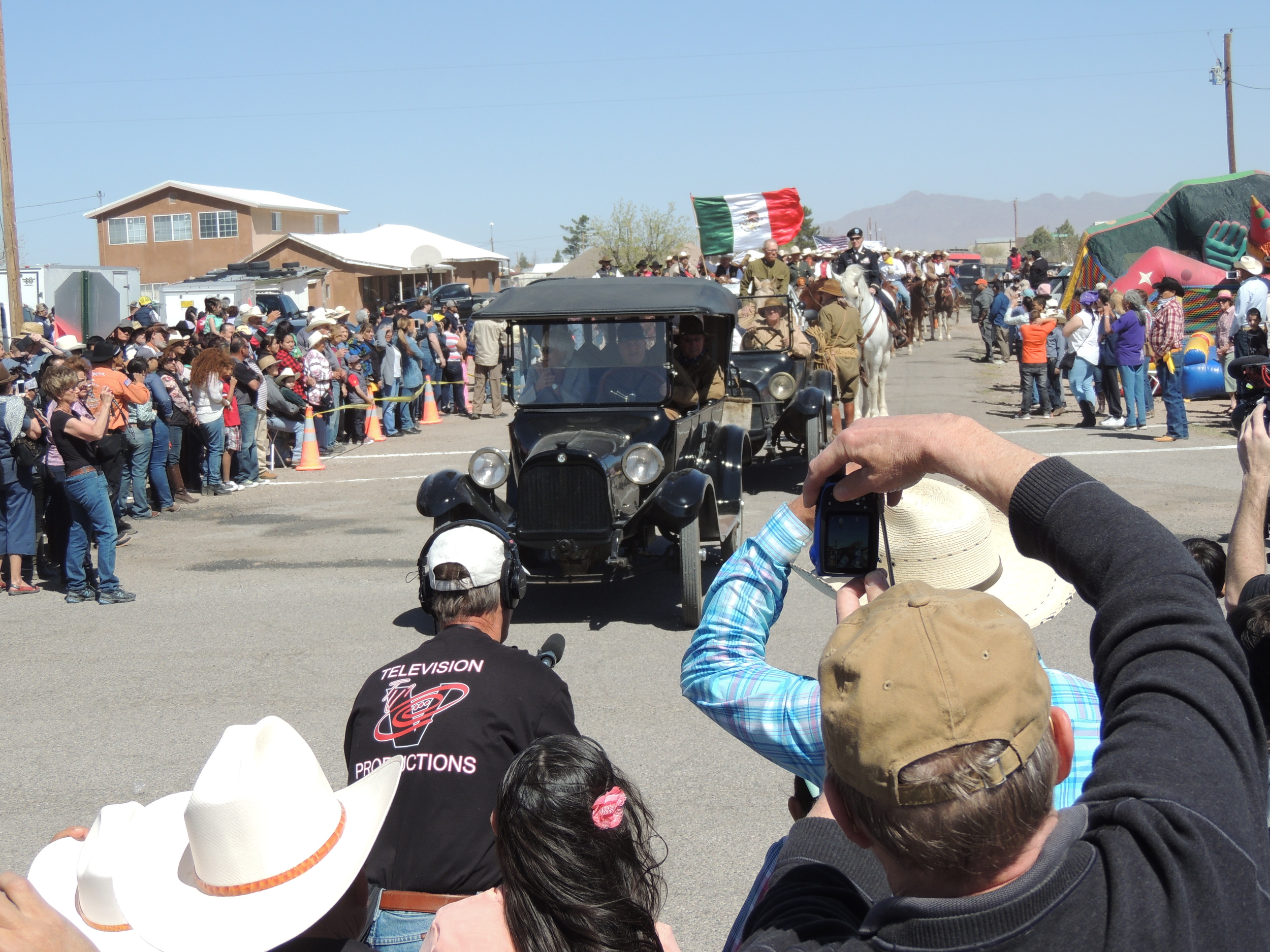 Helen Patton in the company of U.S. army reenactors driving a 1917 Dodge parades by the cheering crowd 