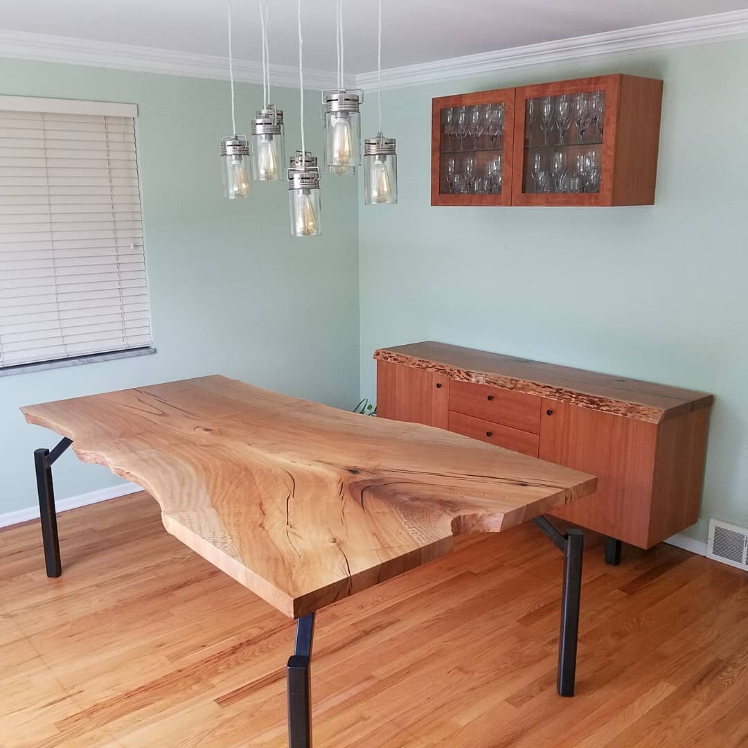 A sideboard and upper cabinet are a new addition to this dining room. The sycamore table was made a few years back. Our design on the cabinet uses hand cut book match cherry veneer done in house to compose the doors, drawers and sides. The top is a s