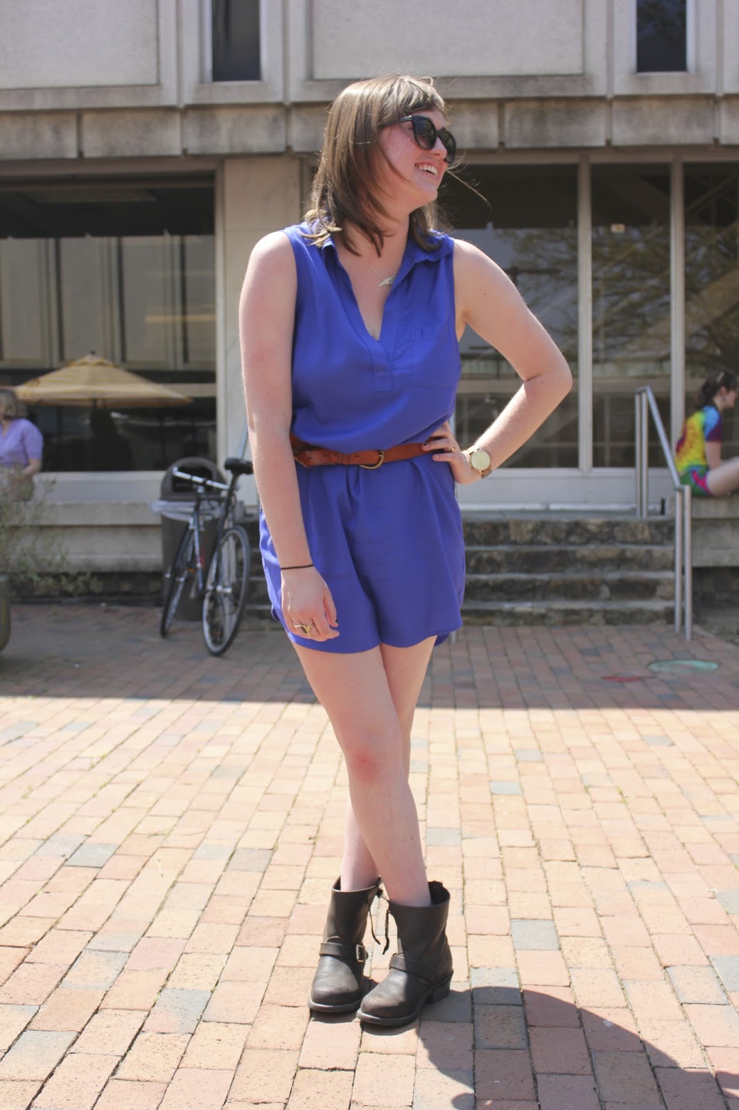  UNC Junior, Nan C. wears a blue sleeveless dress cinched by a brown belt golden buckle and a pair of leather round buckle boots. Also wears a North Carolina state shaped necklace