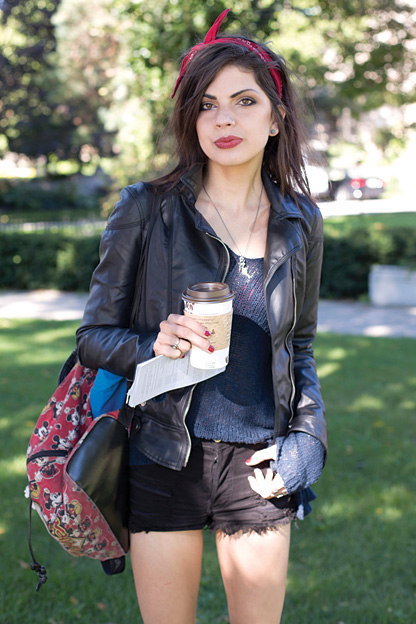 University of Toronto student showcases a rockabilly hipster look combining a leather jacket with a knit top, skinny black jean shorts and a mickey mouse backpack
