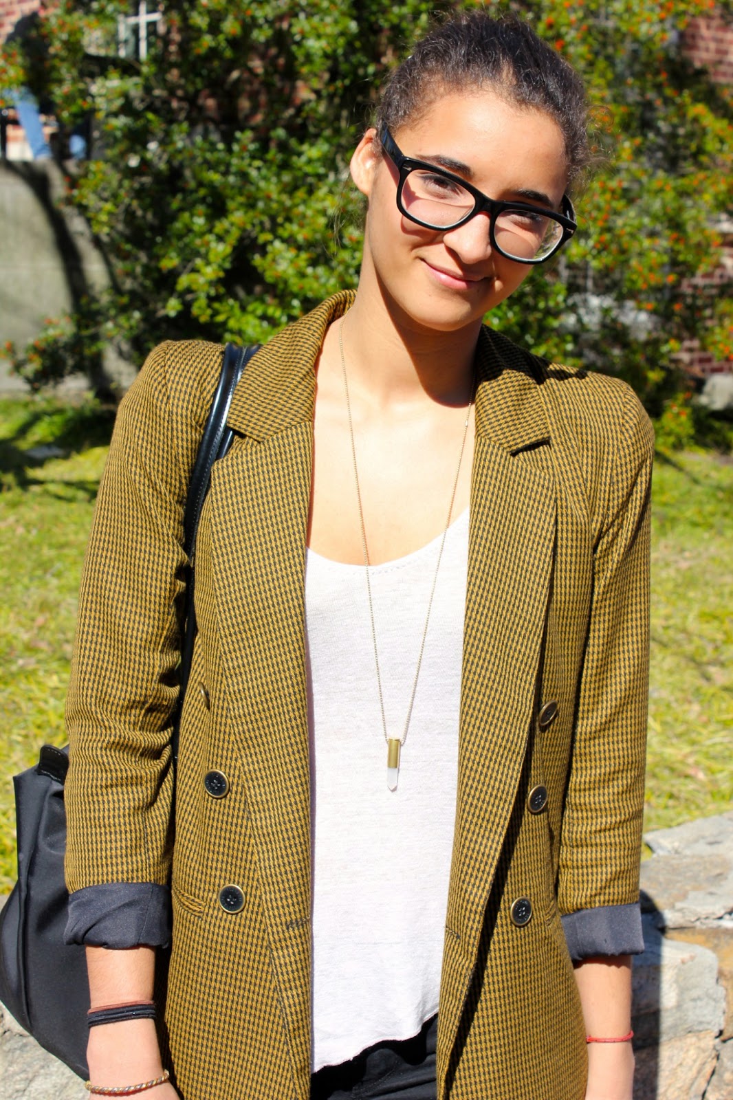 University of North Carolina in Chapel Hill student wears a vintage black and yellow houndstooth tweed blazer sleeves rolled up over a simple white scoop neck tee slim black jeans and black leather combat boots.