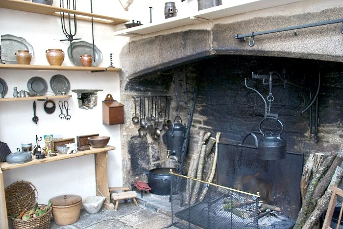 A 16th Century Tudor manor kitchen, courtesy of Home Things Past. The oversized hearth served as a multitasking feature, used for cooking, roasting, heating.