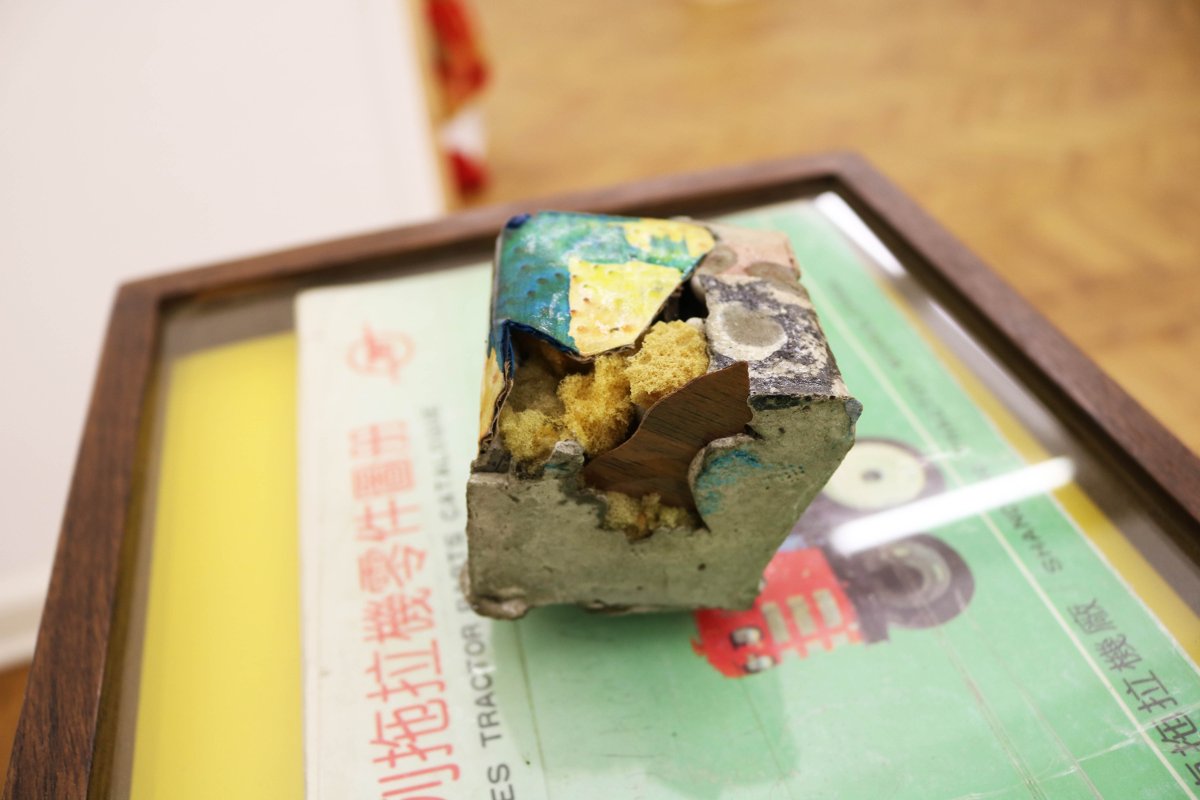 Paperweight #4, detail, 2016, variable materials including framed tractor parts book, variable dimensions, concrete cube 6 x 6 x 6 cm, pedestal structure 20 x 30 x 105 cm.