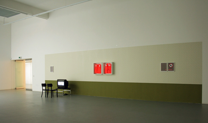  Safety Zoom, 2008-09, video installation 7 min. 13 sec., wall paint, wallpaper, life jackets, painted plywood, photographic paper collage. DV - color, sound, loop. Installation view, Bonner Kunstverein, Bonn, Germany.  WATCH HERE  