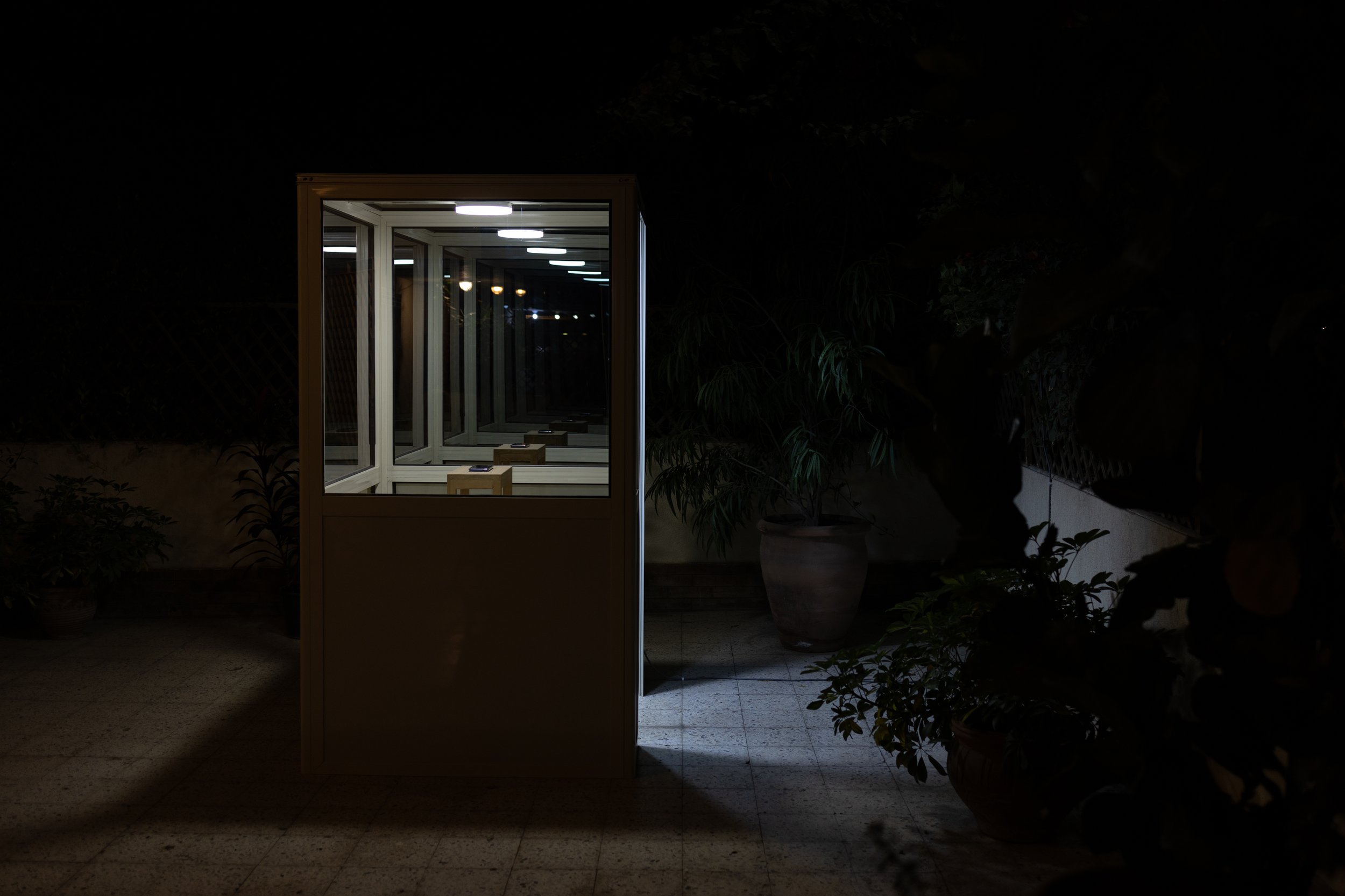  A Structure for a Sunset View, aluminum, wood, mirrored glass, mobile phone, and video on loop.   Installation shot from The Beautiful Captive, Gypsum, 2023. 