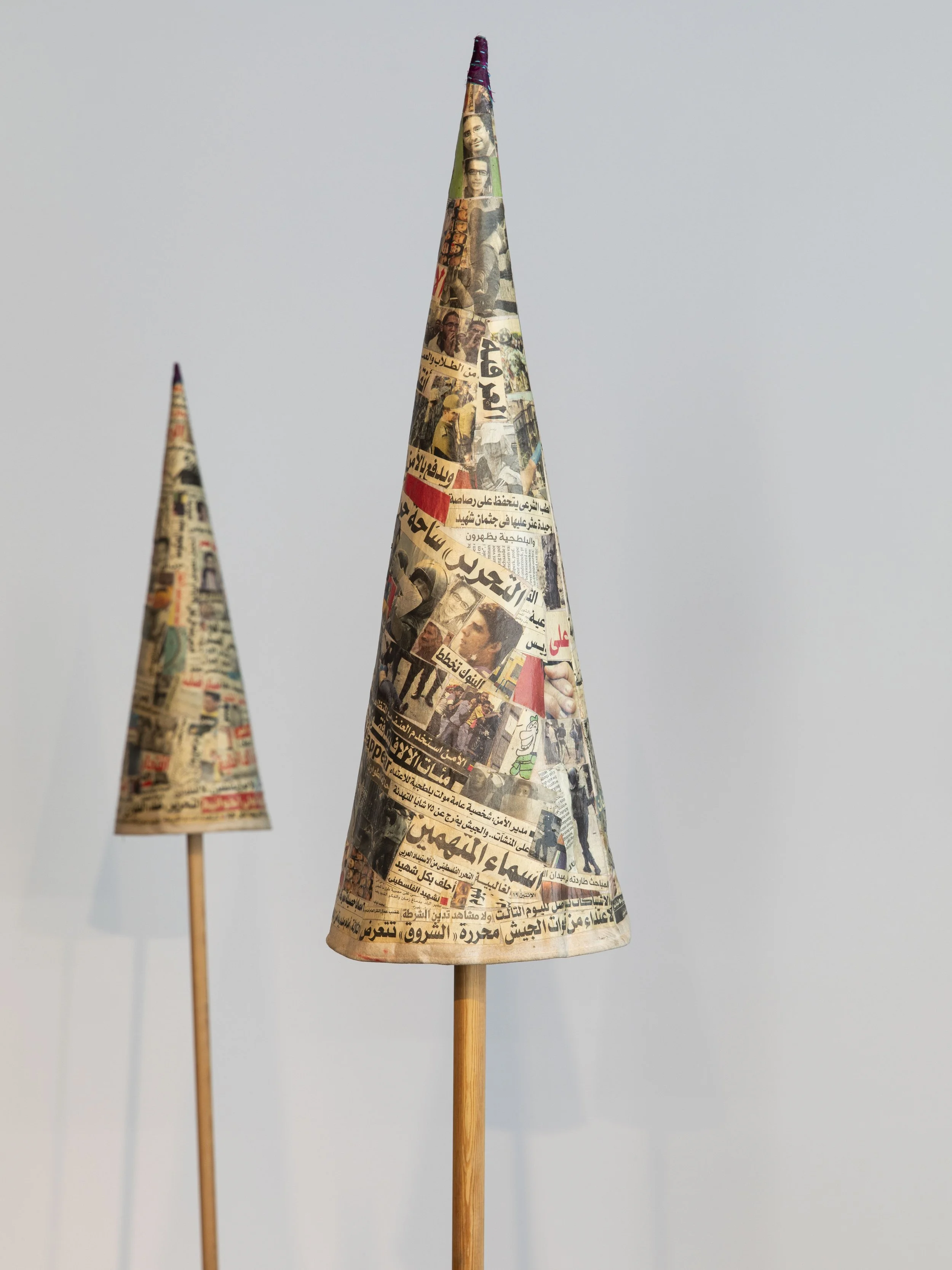  Installation view, 13th Berlin Biennale, KW Institute for Contemporary Art, 2025   The Fool’s Journal , 2013-14, Installation of newspaper cut-outs on fabric and wood, 18 collage pieces: 60 cm H x 22 cm diameter, 35 square meters space  Image: Diana