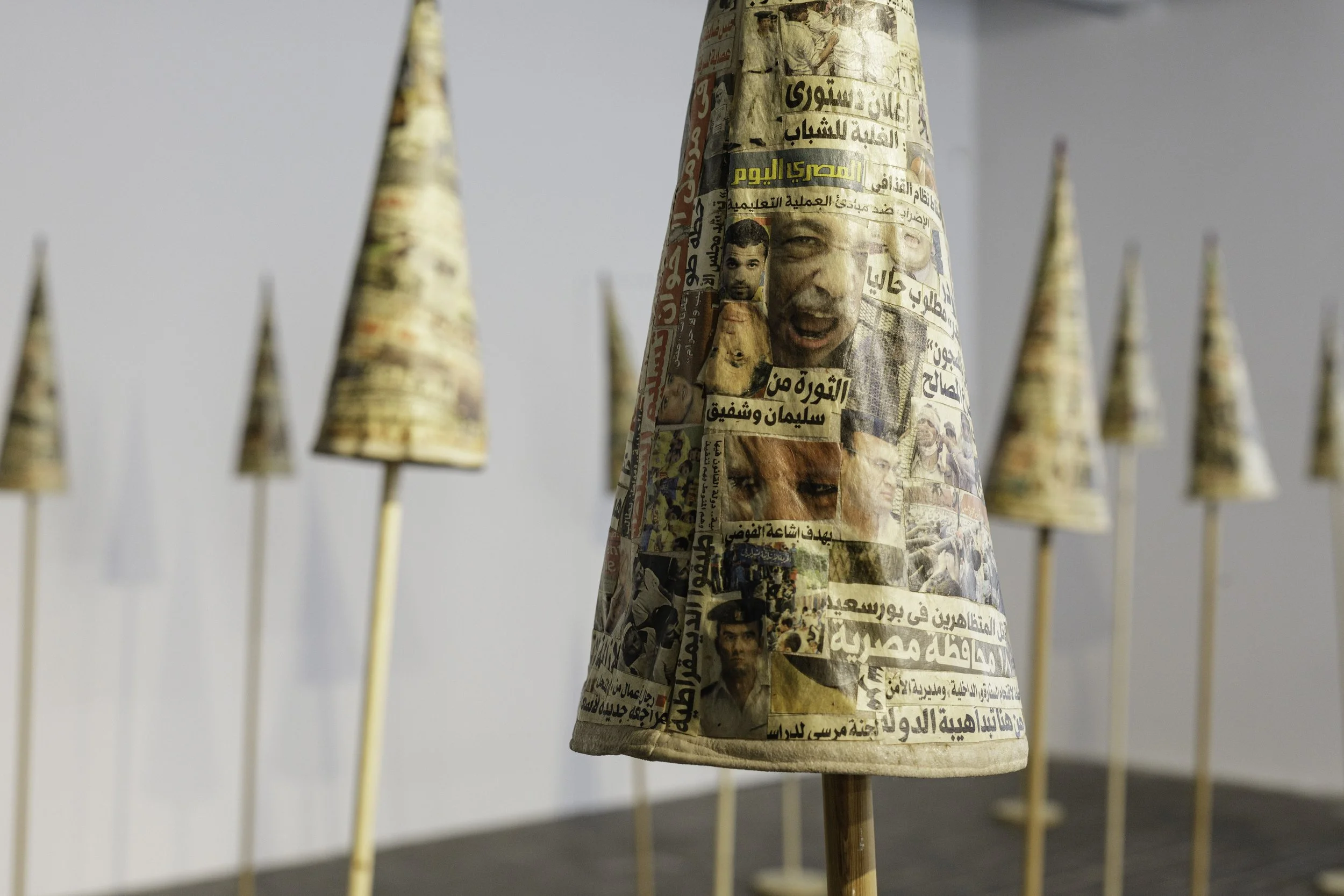  Installation view, 13th Berlin Biennale, KW Institute for Contemporary Art, 2025   The Fool’s Journal , 2013-14, Installation of newspaper cut-outs on fabric and wood, 18 collage pieces: 60 cm H x 22 cm diameter, 35 square meters space  Image: Diana