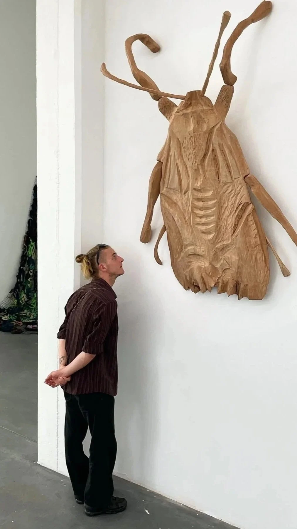   A Dialogue Between a Wooden Moth and Blue Slippers.  2022. Machine-made carpet and hand-carved cherry wood.   Installation view of  Peace or Never – Next Generation Graduation Exhibition  at Kunsthaus Baselland, Münchenstein, Switzerland, 2022. 