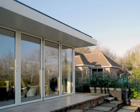 Glazed Extension, Lewes The owners of this house in Lewes wanted a fully glazed extension to make the most of the stunning views across the South Downs. The bi-fold doors fold right back to create a large inside/outside space during warm weather. We worked closely with the owners and the contractor to ensure the extension was of the highest possible quality while staying within budget.