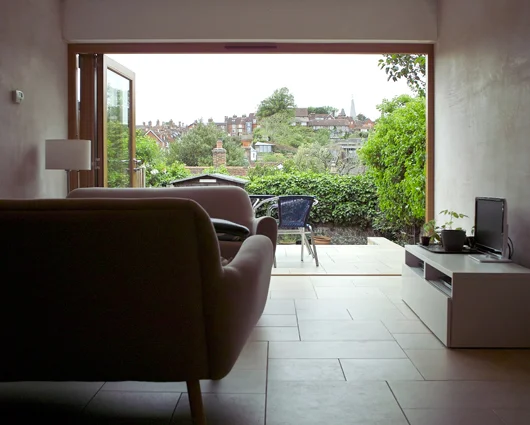 House Refurbishment, Lewes The full-width glazed doors create a stunning space with views across Lewes. The floor tiles continue onto the terrace, bringing inside and outside together.