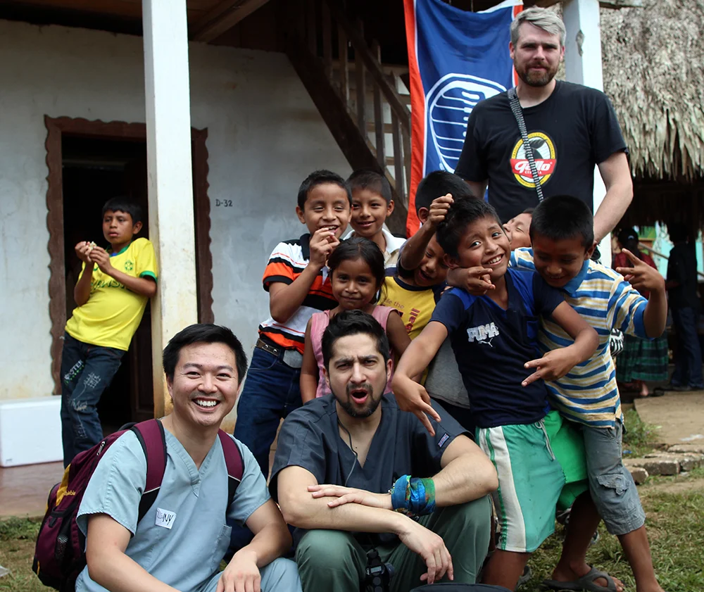 Dr. Leong and other mission team members get their picture taken with some local Chisec children. (You'll note the prominence of the Oilers flag on the facility.)
