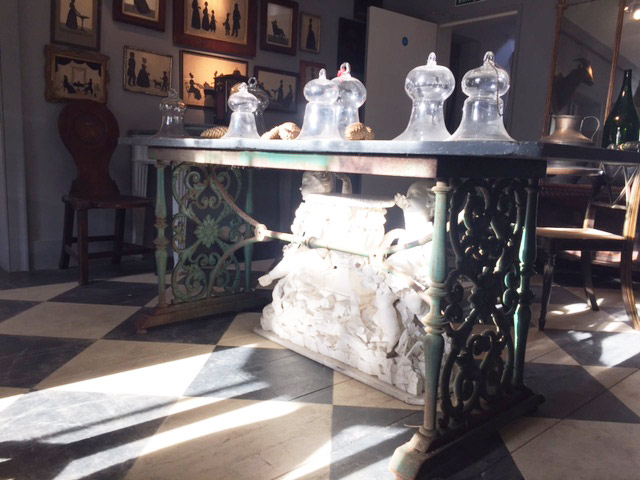 This is what I love. Classic English cast iron conservatory table, topped with Georgian glass smoke bells. 