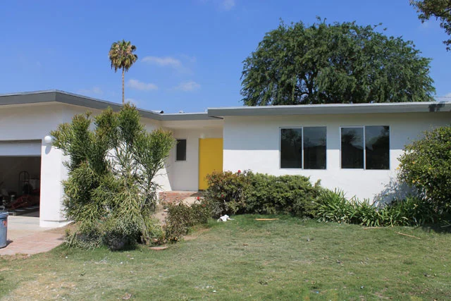 The house got all new white stucco, all new aluminum windows, A/C taken off the roof, and a yellow door for pop.