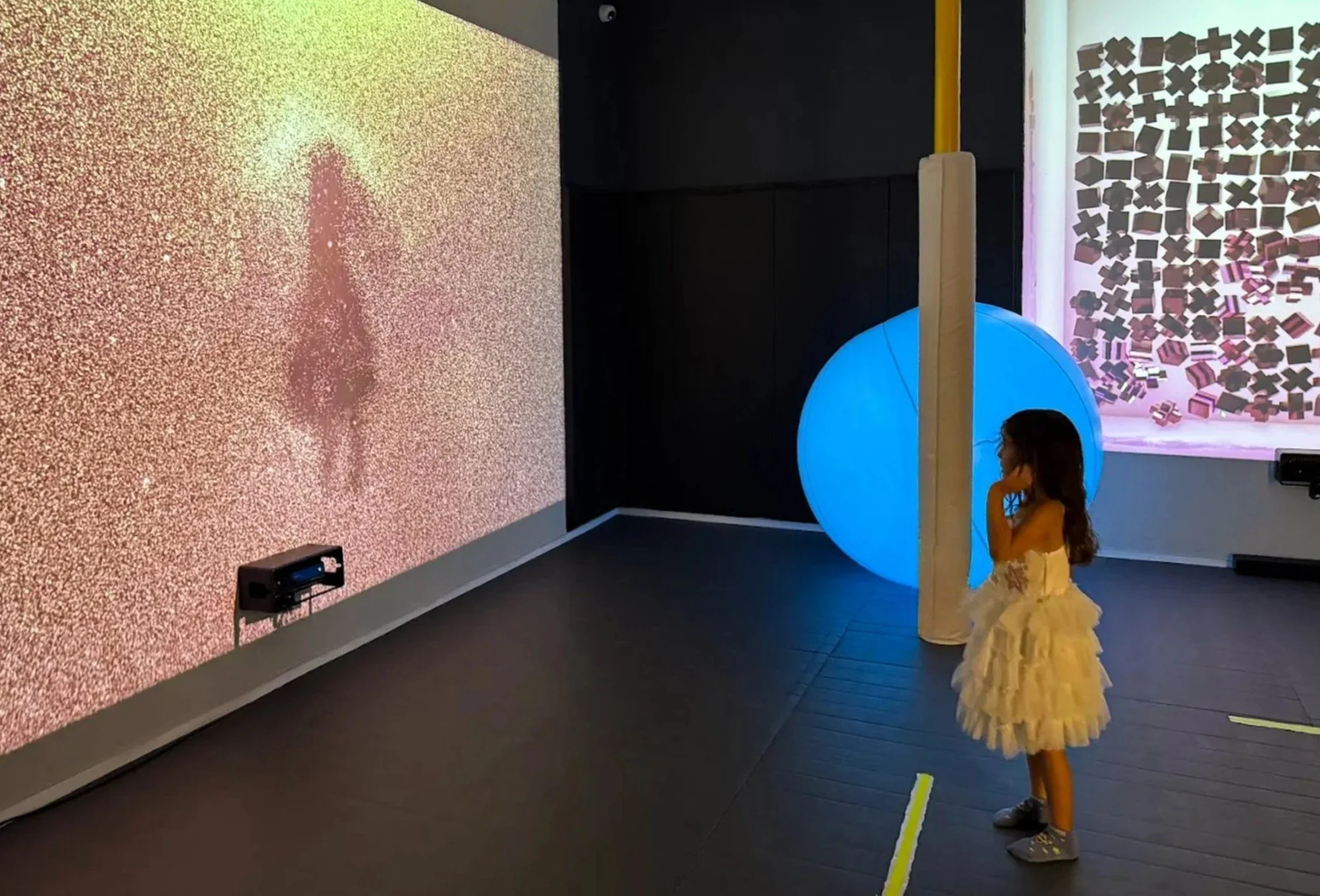 Child interacting with a digital projection experience at Imagine Minds, an immersive technology and art exhibit designed for creative play and discovery.