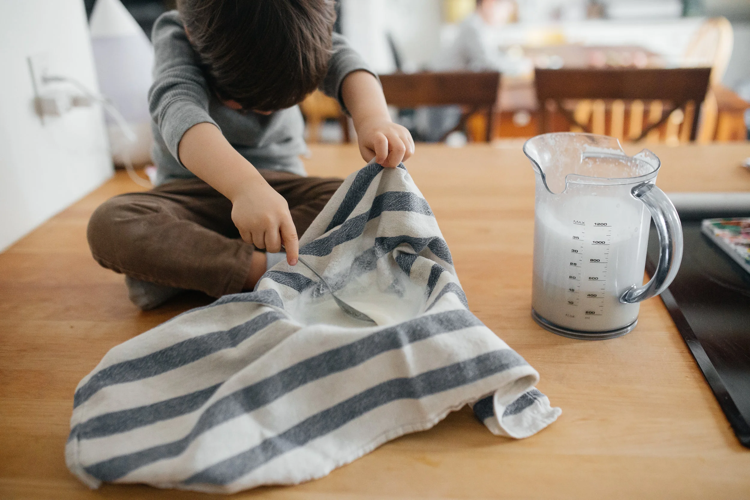 Il regarde le lait s'écouler en dessous. C'est tellement beau la curiosité.