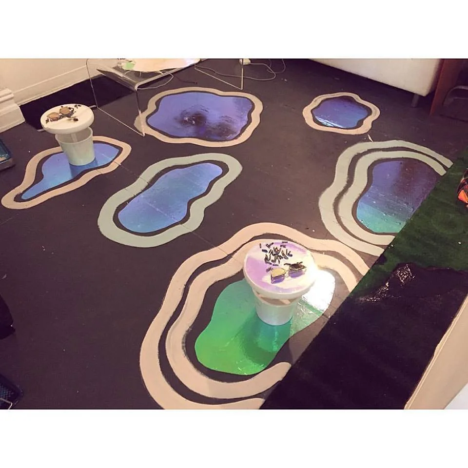 Cloud Forms (famousonmars studio instllation) Installation of iridescent clouds and acrylic paint. Along with green turf and short plastic pedestals with iridescent gems, reflective eyewear, and Riley Chokers. 