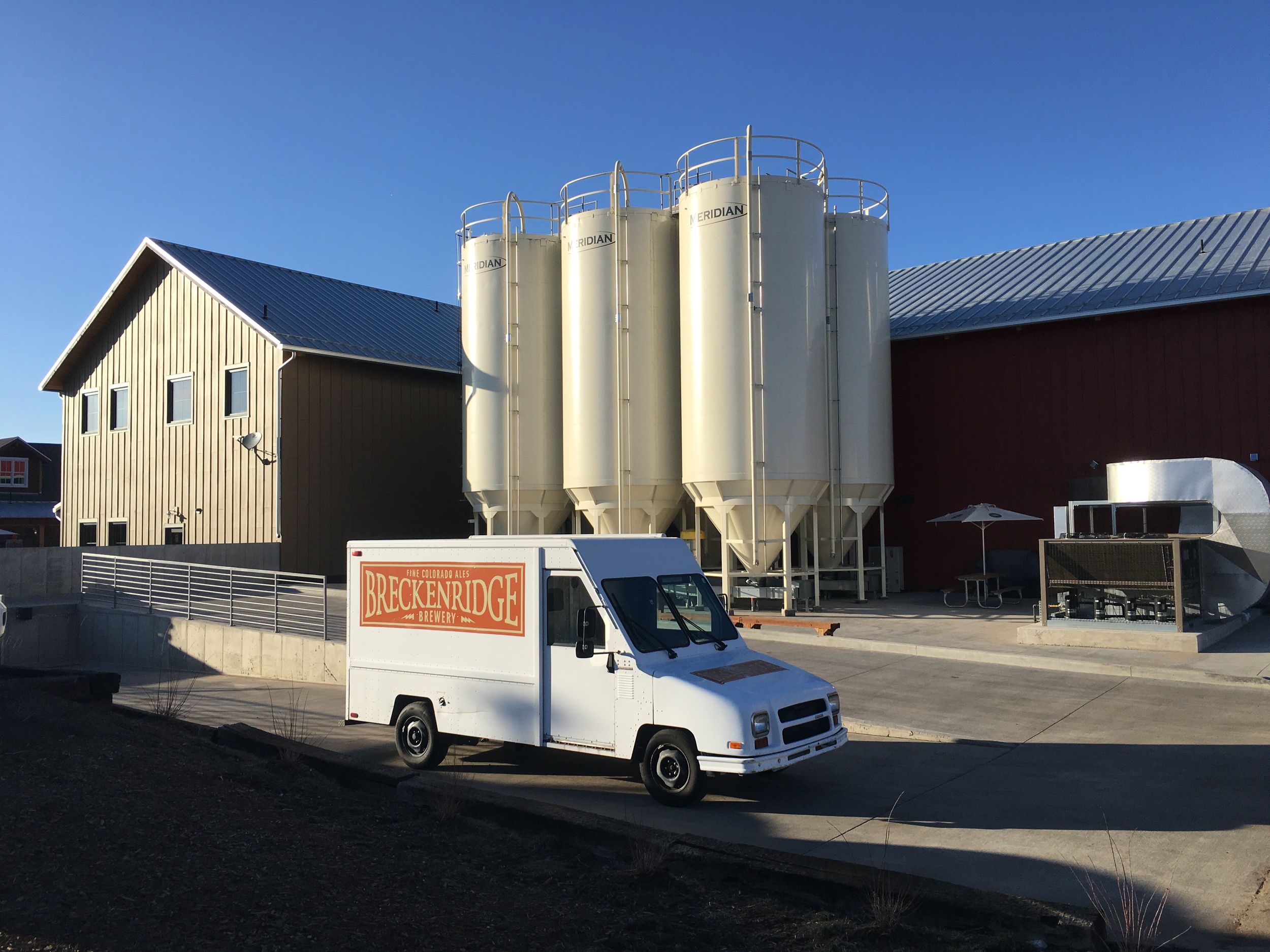 The old 'happy tap truck' in the foreground (it stars in one of our old episodes with them); their new facility in the background.