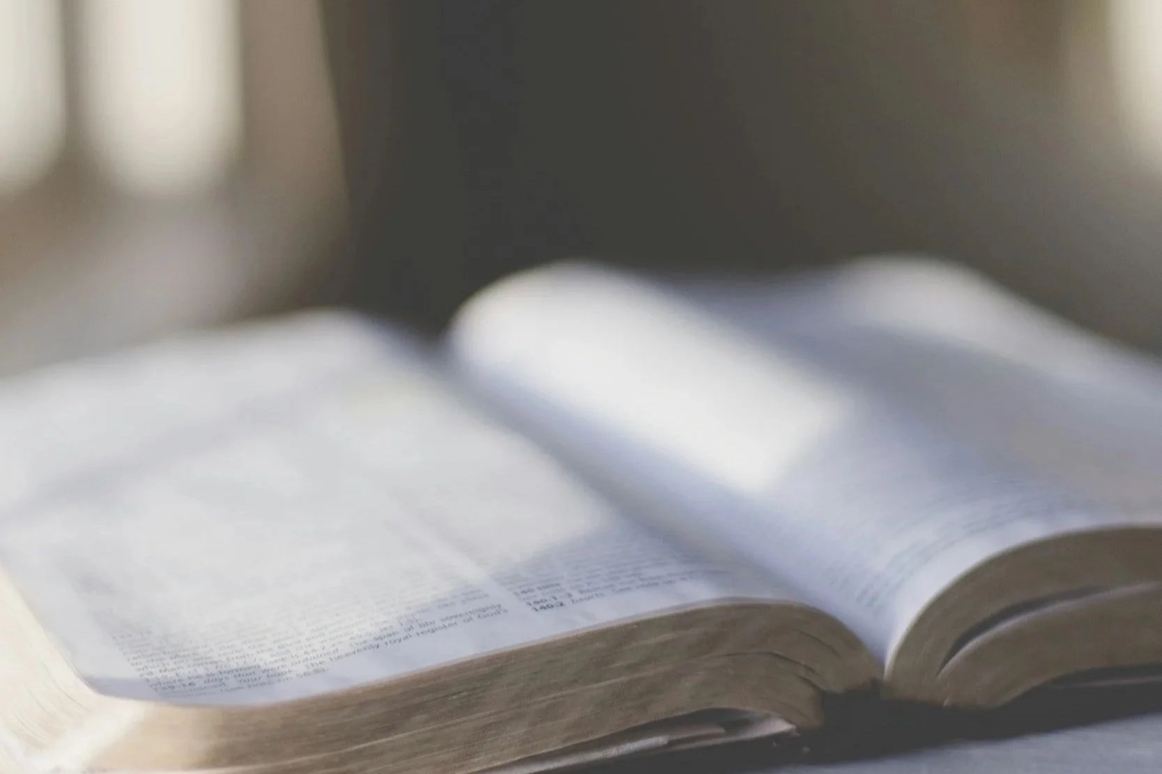 Image of a Bible open on a desk in sunlight