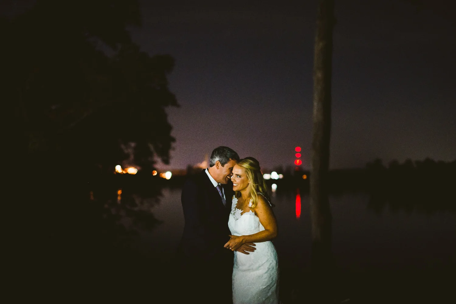 018 - night portrait of the bride and groom smiling next to the james river.jpg