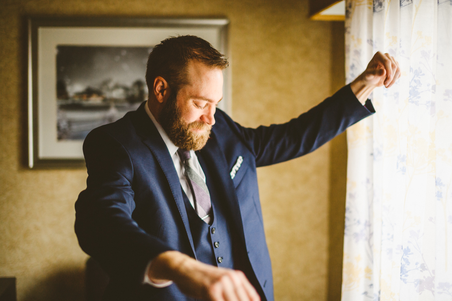 012 - groom laughs as he puts on his jacket.jpg
