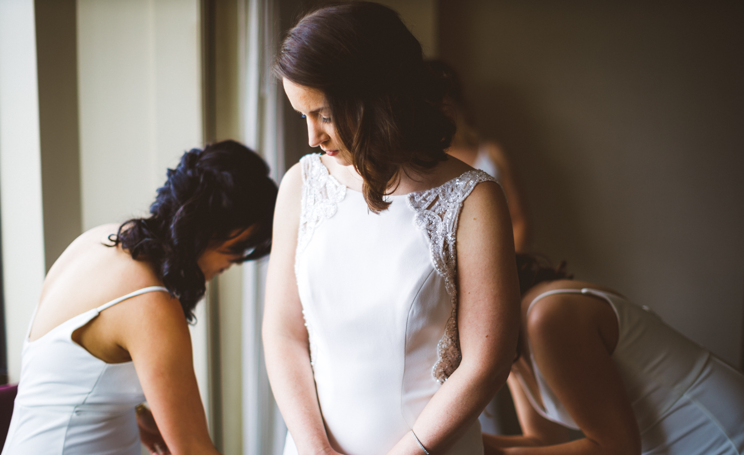 004 - bride getting her dress on with her bridesmaids.jpg