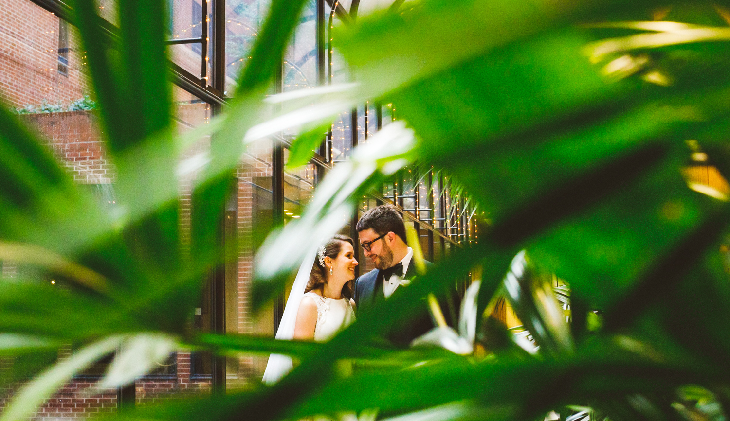 014 - creative portrait of bride and groom in front of palm leaves.jpg
