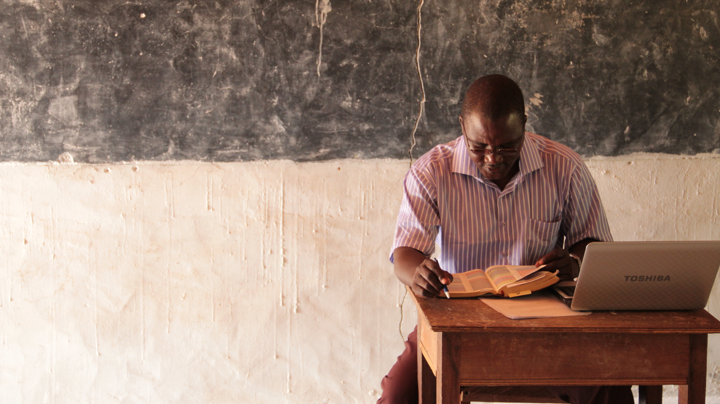  Rev. John Pena, BTS lecturer and Director of Development prepares&nbsp;for the day's &nbsp;lesson.&nbsp; Rev. Pena charges his laptop at home so that he can use it on campus, where the classrooms have no power.&nbsp;&nbsp; 