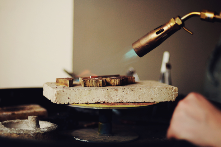 Using a blow torch to heat the metal ready to make into a ring in our jewellery quarter workshop UK 