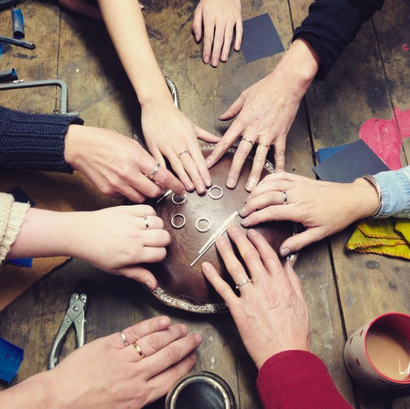 Silver rings on hands made in a jewellery class 