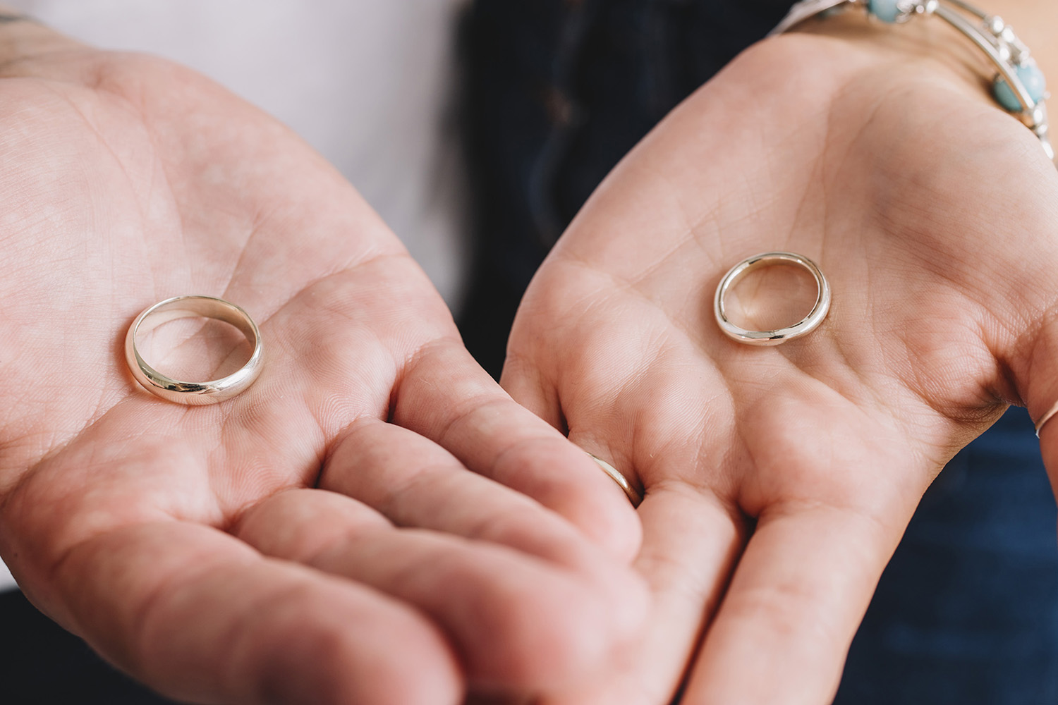 couple holding the wedding rings they made for each other 