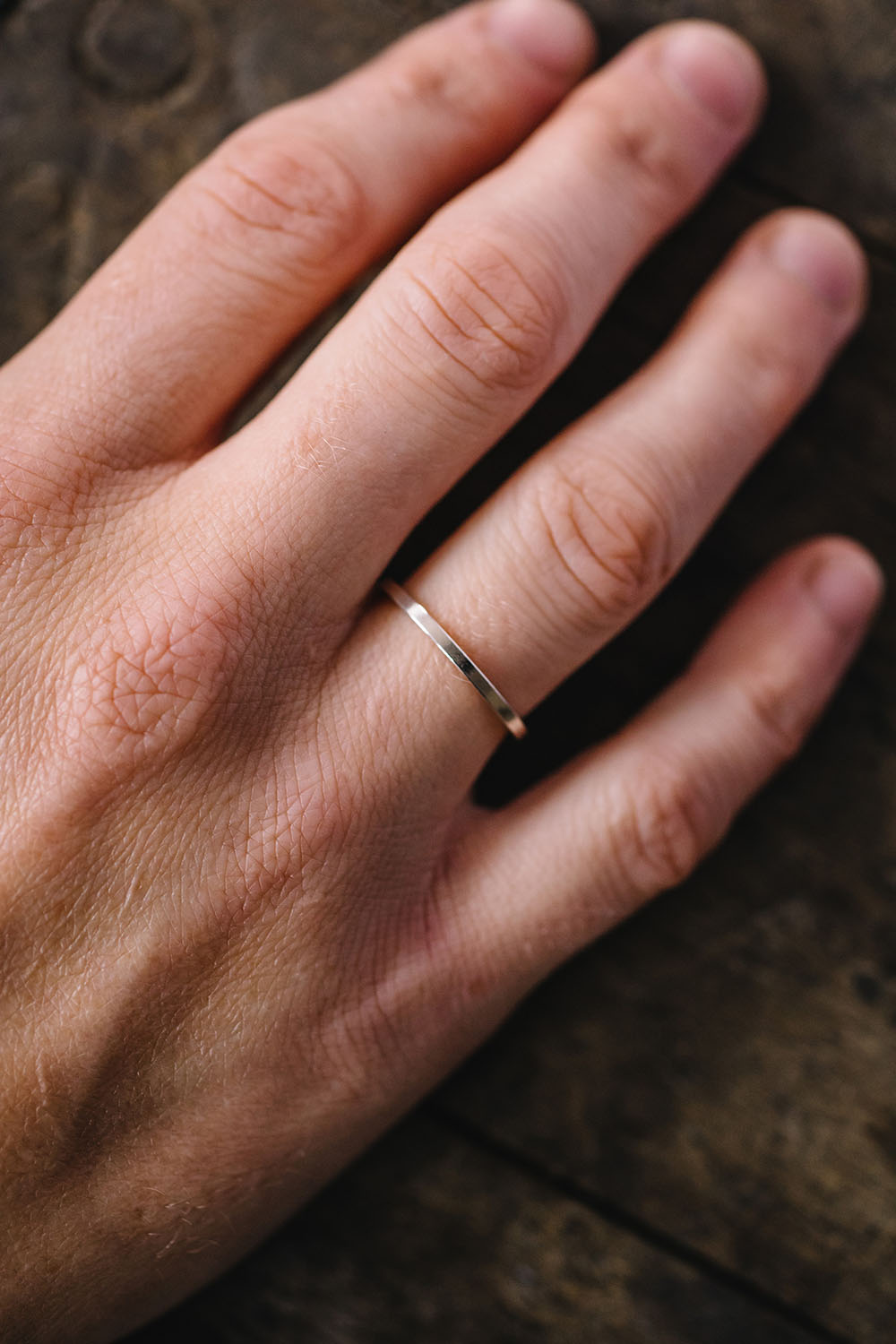 Thin contemporary wedding band on finger 