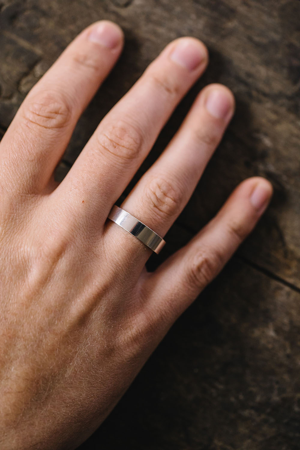 flat modern wedding ring style shown on finger