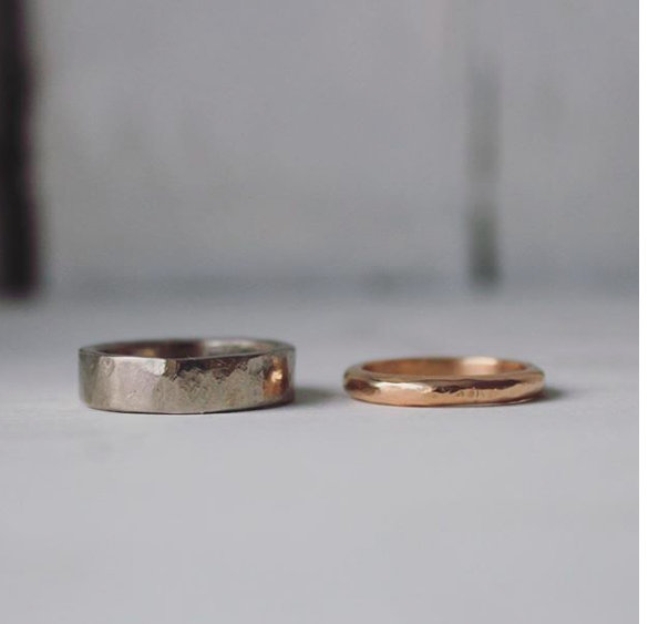 hammered white gold ring next to hammered red gold ring 