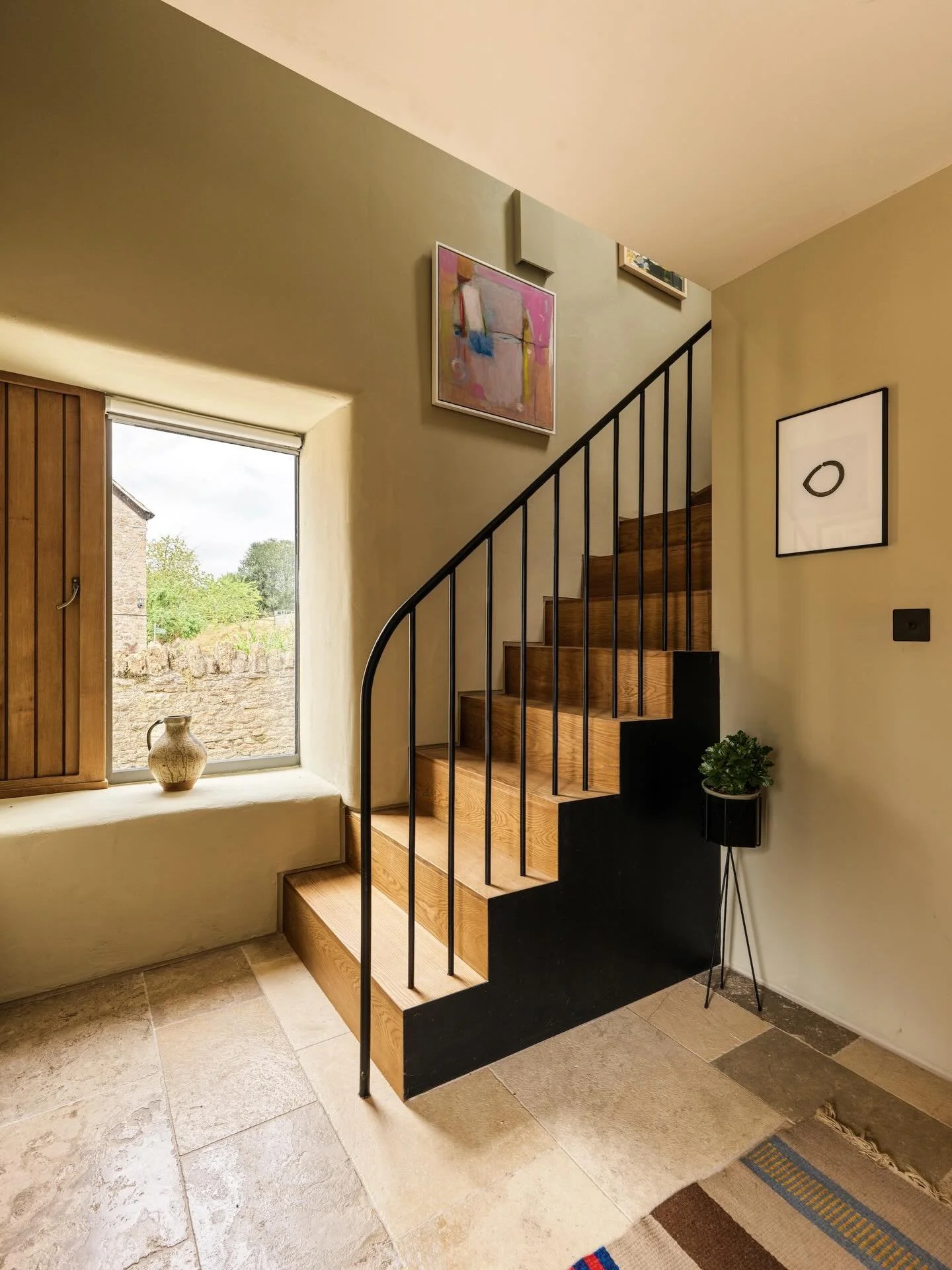 Visitors to this charming property step inside the main barn through a covered loggia, which also connects the art studio and provides shelter throughout the year.

A handcrafted oak staircase with a bespoke metal handrail leads to the guest bedroom,